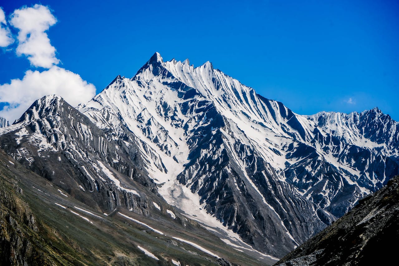 Breathtaking view of snow-covered peaks under a clear blue sky in Himachal Pradesh, India.